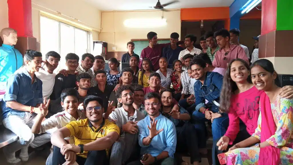 An illustration of a group of people posing for a photo indoors. The individuals are smiling and standing against a wall after learning valuable digital skills through resources.