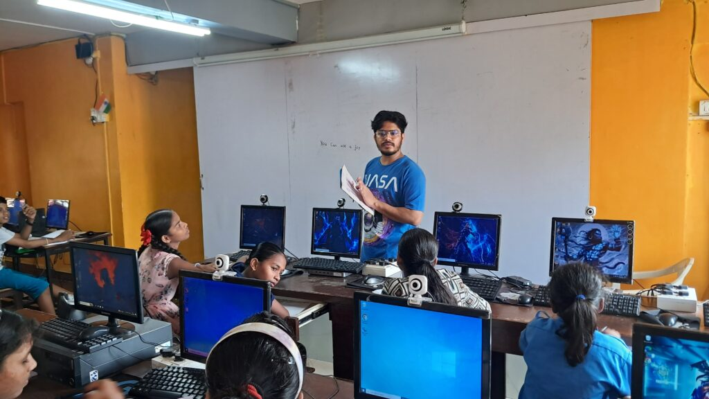 A teacher teaching at ApniPathshala learning pod with each student having a PC.